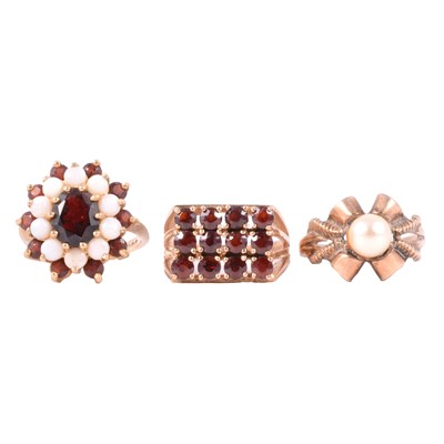 Lot 35 - Two garnet dress rings and a cultured pearl ring.