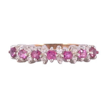 Lot 38 - A pink sapphire and diamond half eternity ring.