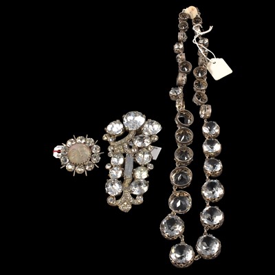 Lot 331 - A graduated paste riviere necklace, large Eisenberg dress clip, Man In The Moon brooch.
