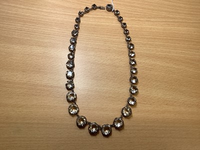Lot 331 - A graduated paste riviere necklace, large Eisenberg dress clip, Man In The Moon brooch.