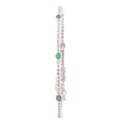 Lot 220 - A delicate emerald and diamond tennis bracelet.