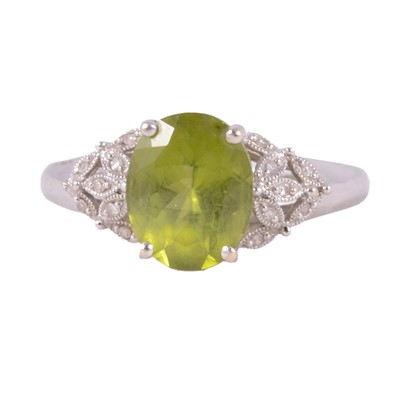 Lot 32 - A peridot and diamond dress ring.