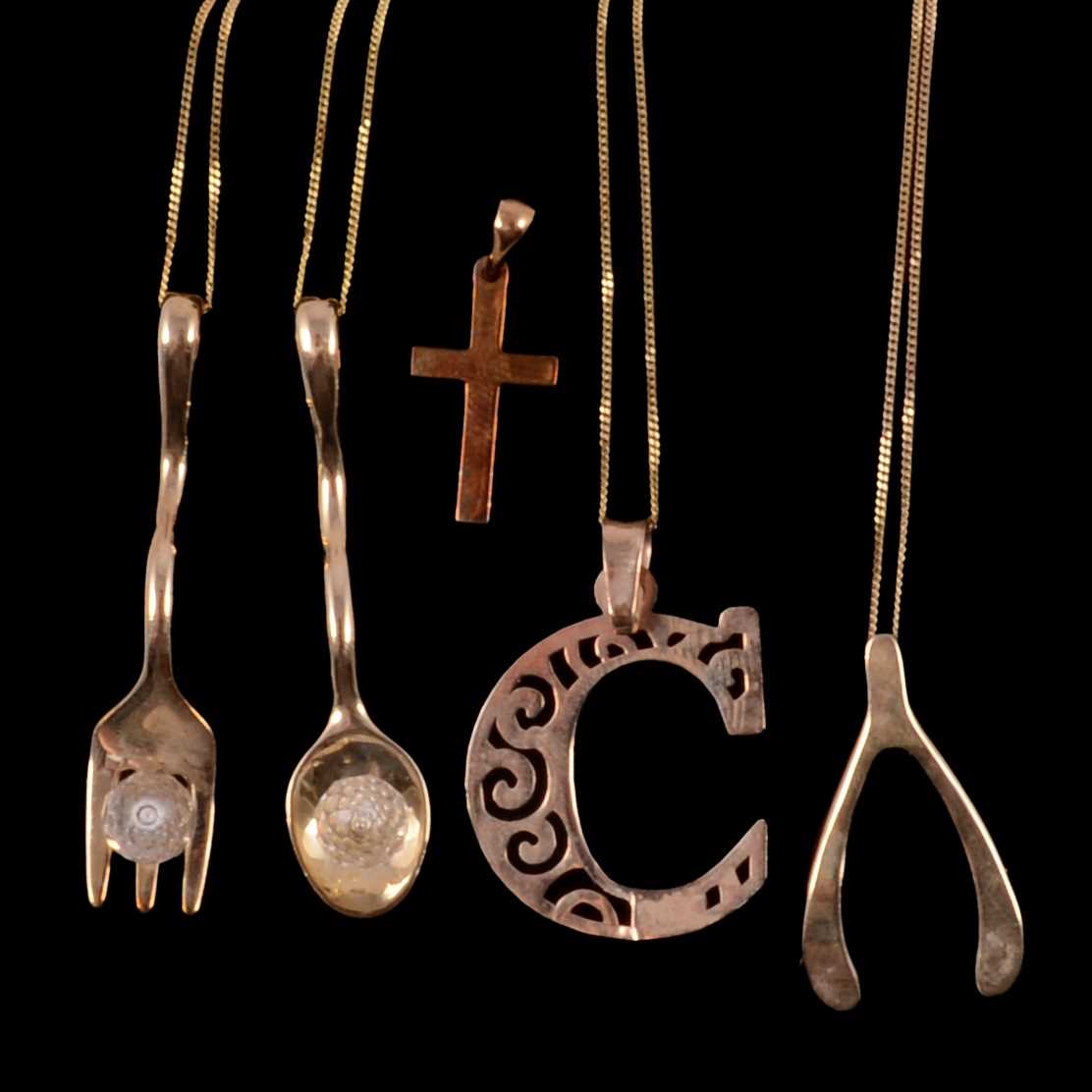 Lot 317 - Five 9 carat gold novelty pendants and four gold chains.