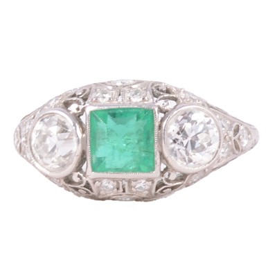 Lot 1 - An emerald and diamond three stone ring with smaller diamonds.