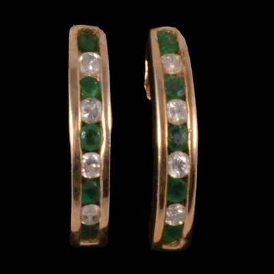 Lot 265 - A pair of emerald and diamond half hoop earrings.