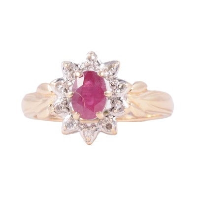 Lot 14 - A ruby and diamond oval cluster ring.