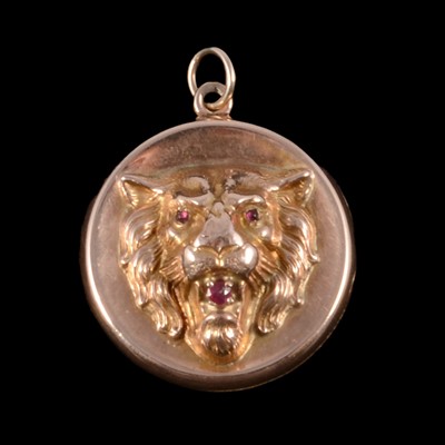 Lot 326 - A yellow metal ruby set lion mask locket.