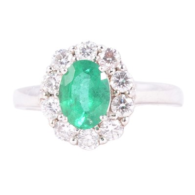 Lot 5 - An emerald and diamond cluster ring.