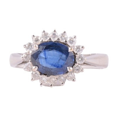 Lot 23 - A sapphire and diamond cluster ring.