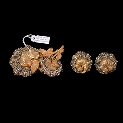 Lot 1183 - Miriam Haskell - a signed gilt metal flower brooch and matching leaf earclips.