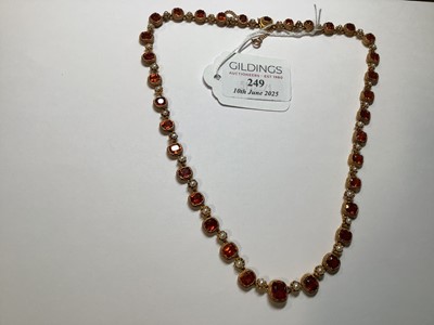 Lot 249 - A hessonite garnet and seed pearl graduated riviere necklace.