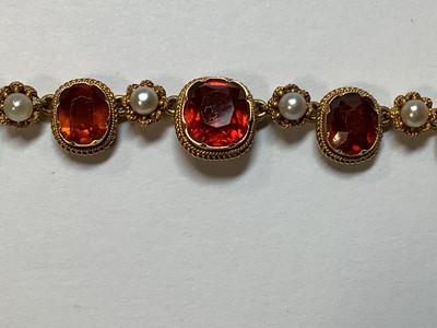 Lot 249 - A hessonite garnet and seed pearl graduated riviere necklace.