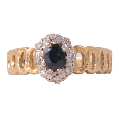 Lot 34 - A sapphire and diamond cluster ring.