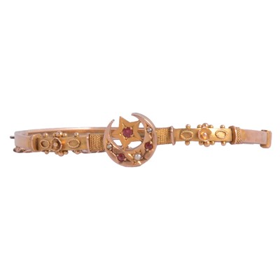 Lot 215 - A yellow metal Etruscan style half hinged bangle.