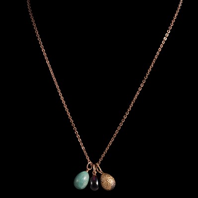 Lot 270 - Eight Imperial Russian Easter egg pendants, a yellow metal chain, and a gilt metal chain.