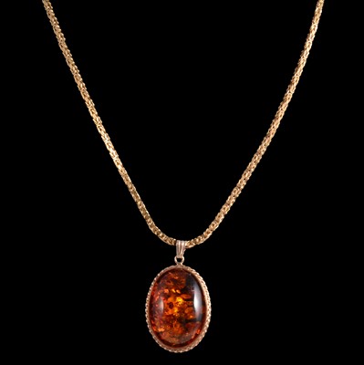 Lot 262 - A 9 carat yellow gold amber pendant on a Kings pattern chain.