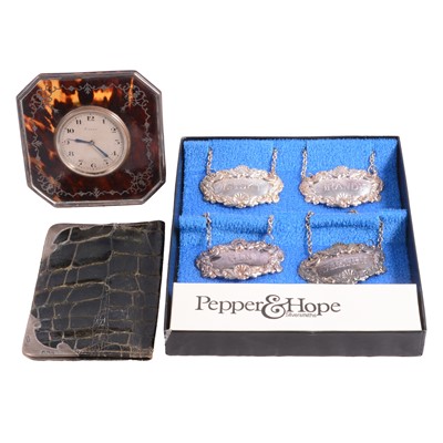Lot 1133 - Silver and tortoiseshell travel clock, silver mounted wallet, four plated decanter labels
