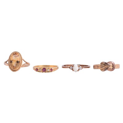 Lot 13 - Four gold dress rings, citrine, ruby, opal and a plain gold knot ring.
