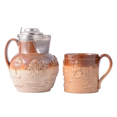 Lot 42 - A Victorian salt glazed harvest jug with silver lidded mount and another tankard.