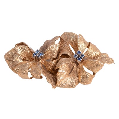 Lot 237 - A 9 carat yellow gold double flower head brooch set with sapphires.