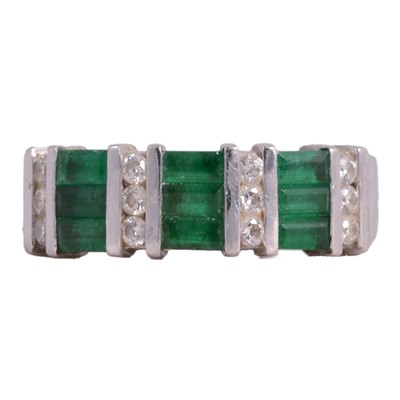 Lot 59 - An emerald and diamond half hoop ring.
