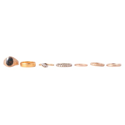 Lot 144 - Seven gold rings including a diamond three stone crossover ring.