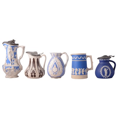 Lot 132 - Twelve pottery jugs, mostly relief-moulded