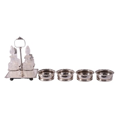 Lot 313 - George V silver four-bottle cruet stand, and set of four silver bottle coasters