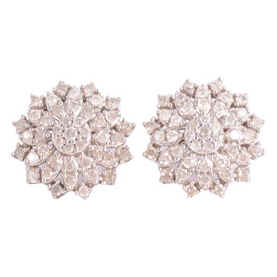 Lot 322 - A pair of diamond cluster earrings in silver mounts.