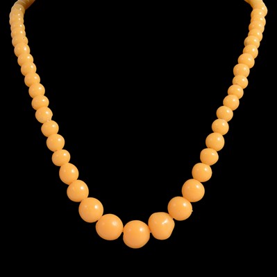 Lot 331 - An egg yoke coloured amber style necklace with graduated beads.