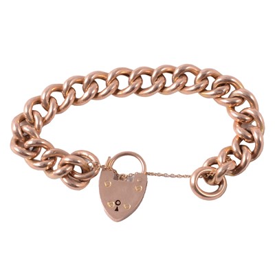 Lot 306 - A yellow metal hollow curb link bracelet with padlock fastener.