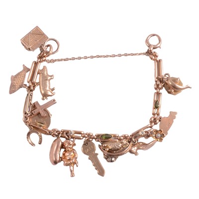 Lot 303 - A yellow metal bracelet set with tourmaline and diamonds with charms attached.