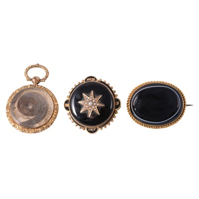 Lot 204 - A mourning brooch, a banded agate brooch, and a hair locket.