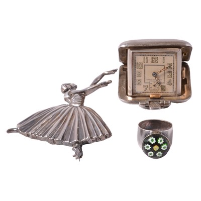 Lot 468 - A white metal ballerina brooch, small silver-cased clock, and silver ring.