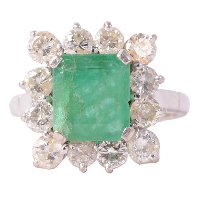 Lot 21 - An emerald and diamond cluster ring.