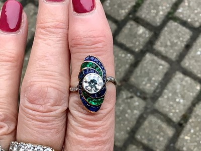 Lot 20 - An Art Deco diamond ring with emerald and sapphire surround.