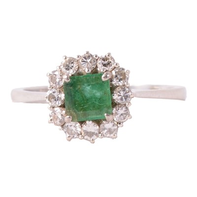 Lot 23 - An emerald and diamond cluster ring.