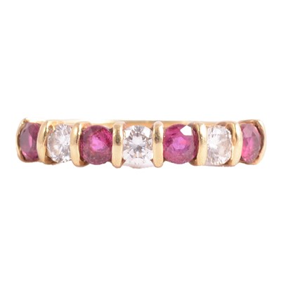 Lot 39 - A ruby and diamond half eternity ring.