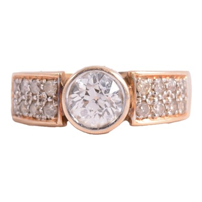 Lot 57 - A diamond solitaire ring with diamond shoulders.