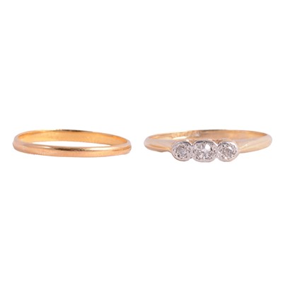 Lot 137 - A 22 carat gold wedding band, and a three stone diamond ring.