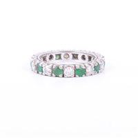 Lot 182 - An emerald and diamond full eternity ring, ten...
