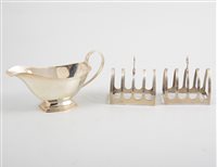 Lot 486 - A pair of silver toast racks and a sauce boat,...