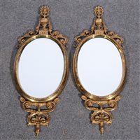 Lot 432 - Pair of cast brass wall mirrors, urn finials,...