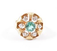 Lot 199 - A diamond set dress ring, the central green...