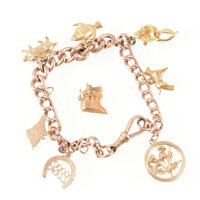 Lot 290 - A rose metal charm bracelet, hollow graduated...