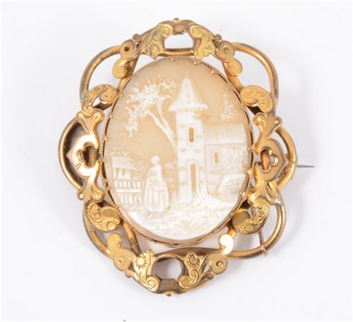 Lot 216 - A Victorian oval cameo brooch, village scene with church 35mm x 28mm, in a gold-plated scroll design mount.