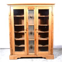 Lot 443 - A modern pine cabinet, with two glazed panel doors.