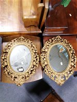 Lot 472 - Pair of cast gilt metal oval mirrors.