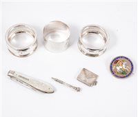 Lot 235 - Three silver napkin rings, mother of pearl fruit knife with silver blade, silver stamp case with Chester hallmark, pencil, enamelled crown brooch, (7).