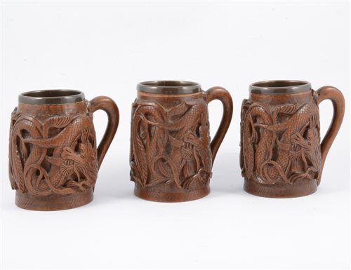 Lot 100 - A set of six Shanghai carved wooden tankards, metal lined.